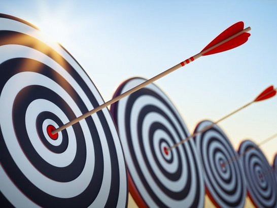 Fünf Zielscheiben mit je einem Pfeil in der Mitte.