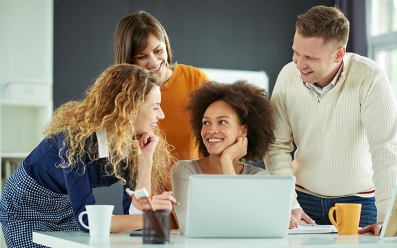 Vier Personen rund um einen Laptop.