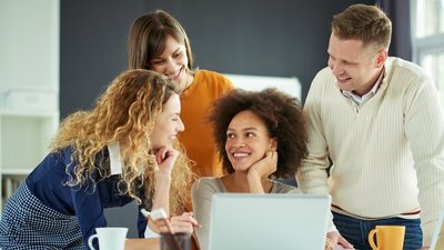 Vier Personen rund um einen Laptop.