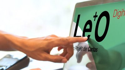 Zwei Hände auf Laptop-Tastatur, eine weitere Hand zeigt auf den Bildschirm des Geräts.