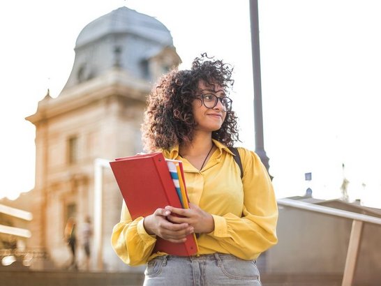 Frau mit roter Mappe im Arm.
